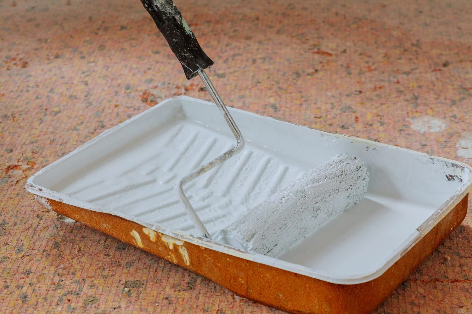 Realistic image of paint pan and roller on drop cloth during painting project