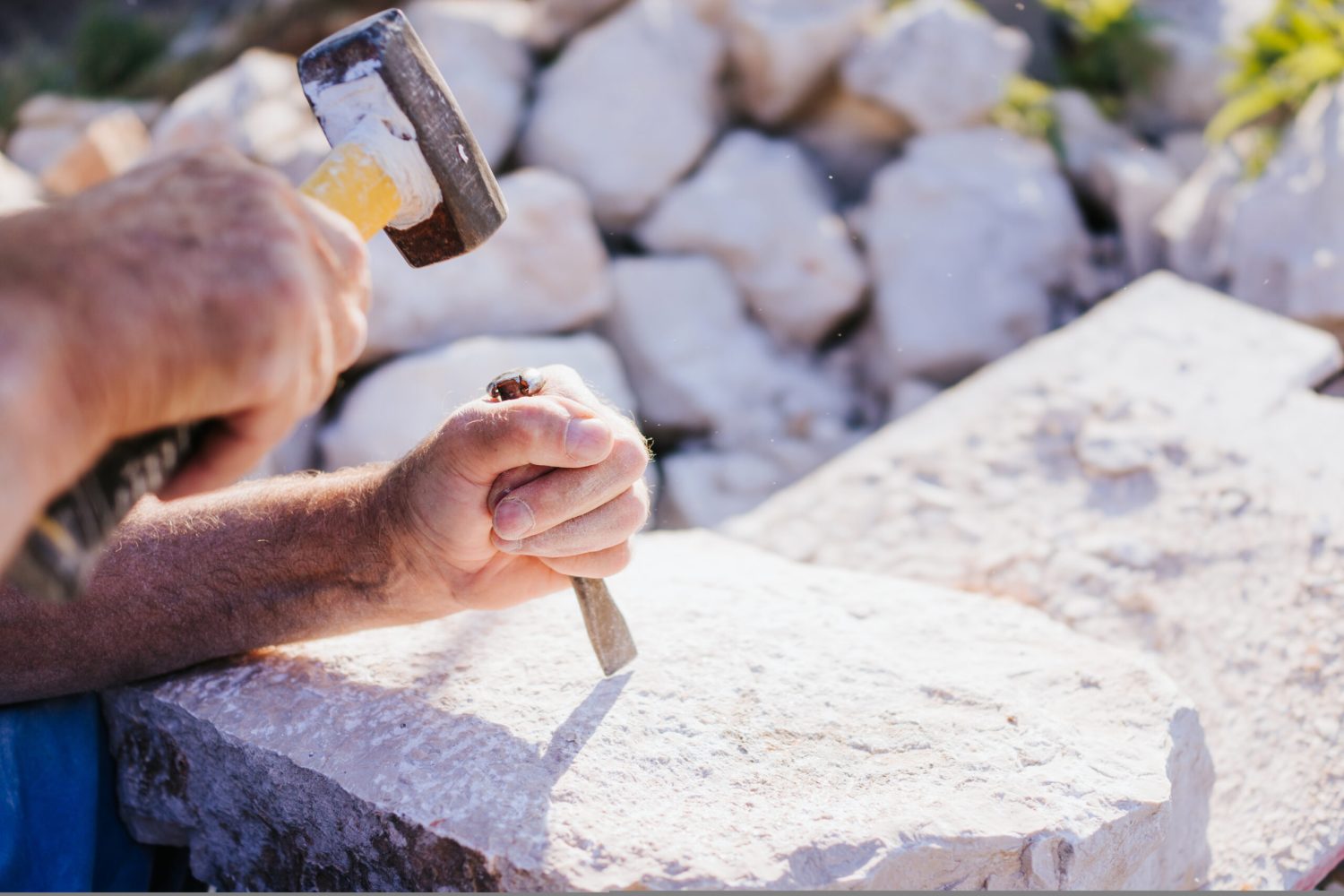 Stone carver working with hammer and chisel